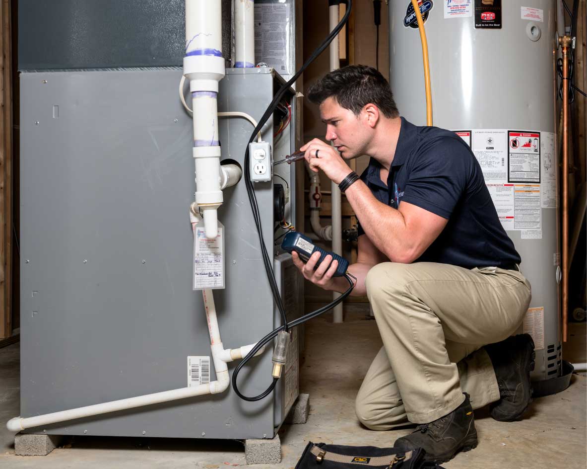 HVAC technician using a diagnostic tool during an AC load assessment in a Dallas home