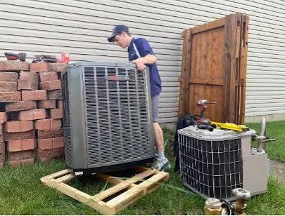 New and old AC condenser units side by side on a pallet during a Dallas central AC replacement